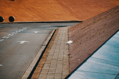 High angle view of dirty footpath by wall in city 