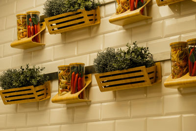 Spices in glass jars on shelf, wooden glass cups on kitchen wooden wall. cookware concept