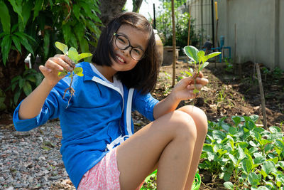 Portrait smiling girl holds the vegetable during harvesting from the planting garden at backyard