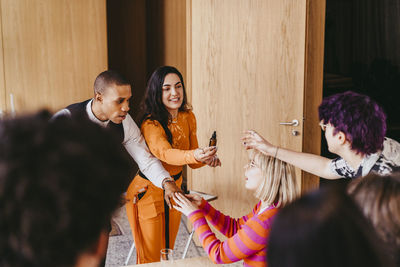 Businesswoman distributing essential oil samples to colleagues during event at convention center