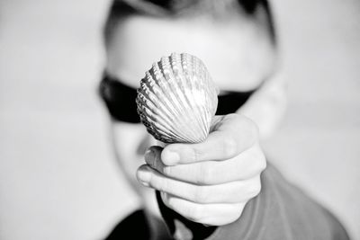 Close-up of man showing seashell