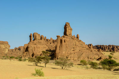 Rock formations in desert against clear blue sky