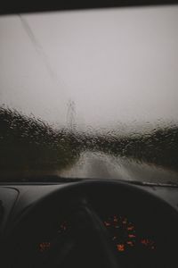 Road seen through wet windshield during rainy season