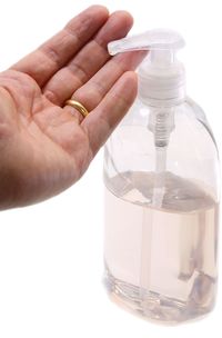 Close-up of hand holding glass bottle against white background