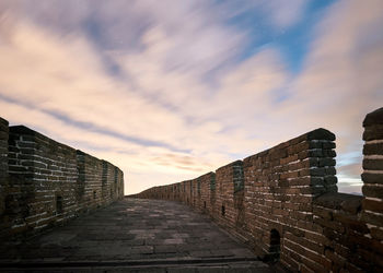 Stone wall of historic building against sky