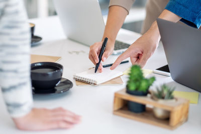 Midsection of business people working on table