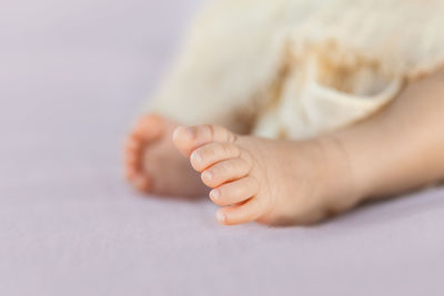 Low section of baby feet on bed