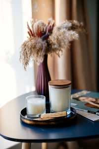 Incense sticks cozy stylish interior coffee table and bouquet of dried flowers, magazine and candles