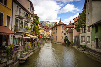 Canal amidst buildings in town against sky