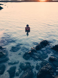 Rear view of man on sea against sky