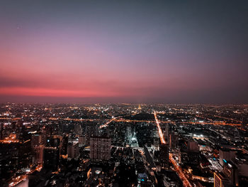 High angle view of illuminated buildings against sky at night