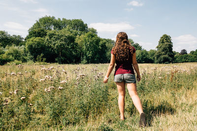 Rear view full length of woman standing on grassy field