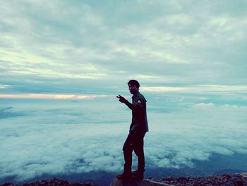 Portrait of man standing on mountain against sky