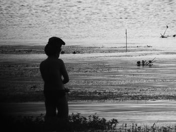 Rear view of silhouette man standing on beach