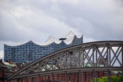 Low angle view of bridge against cloudy sky