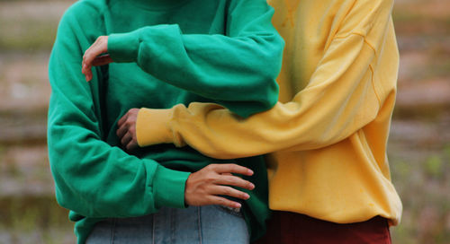 Midsection of couple standing on field