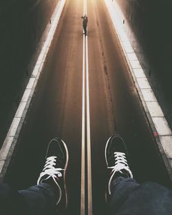 Low section of man standing on road