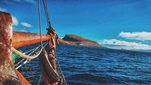 Boats in sea against cloudy sky