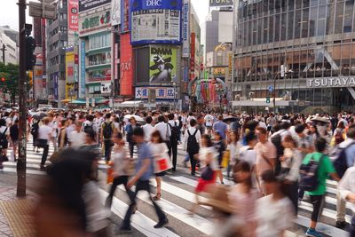 Crowd walking on street in city