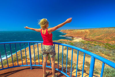 Rear view of woman with arms outstretched standing at kalbarri national park 