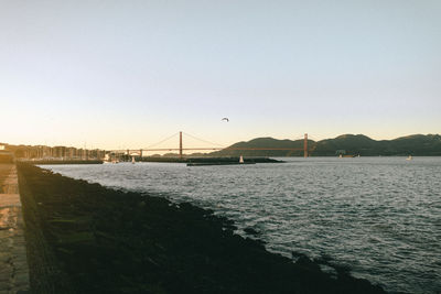 Bridge over sea against clear sky