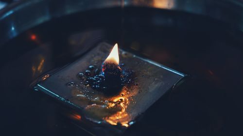 High angle view of lit tea light candles