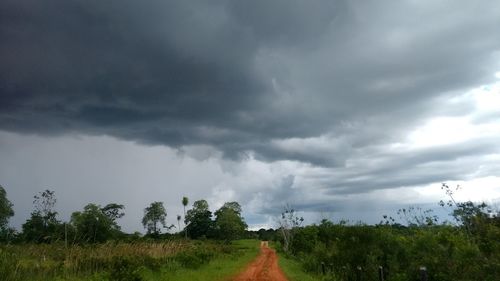 Scenic view of golf course against cloudy sky