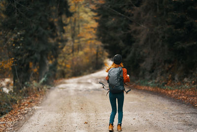 Rear view of man walking on road