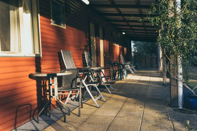 Empty chairs and tables by wall