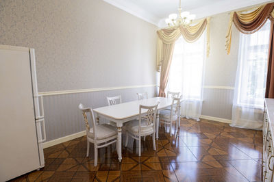 Spacious kitchen in a house with white furniture light walls.