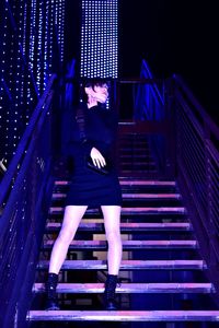 Low angle view of woman on staircase at night