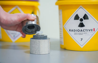 Close-up of hand holding yellow sign