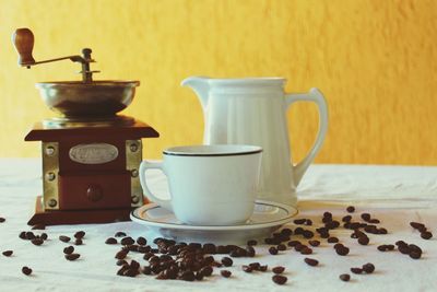 Close-up of coffee cup and grinder on table