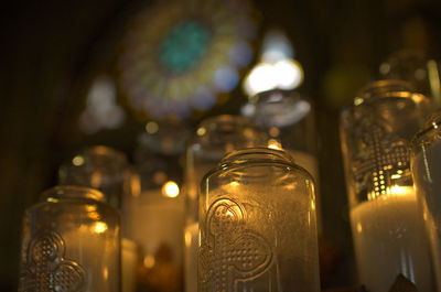 Close-up of candles in glass bottles on table