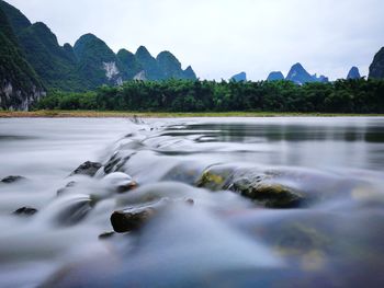 Scenic view of trees and mountains against sky