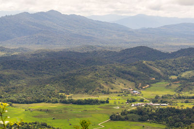 High angle view of field and mountains against sky