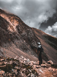 Man standing on rock against sky