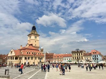 People in front of historic building against sky