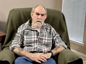 Portrait of man sitting on chair at home