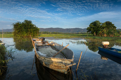 Boat moored in lake against sky