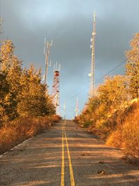 Road amidst autumn trees against sky