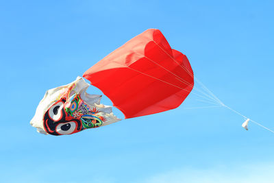 Low angle view of kite flying in blue sky