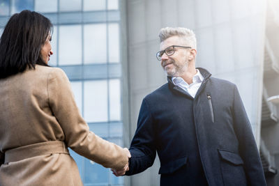 Business people shaking hands outdoors