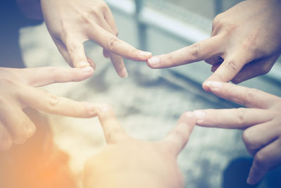 Close-up of couple hands against sky