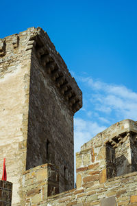 Low angle view of old ruin building against blue sky
