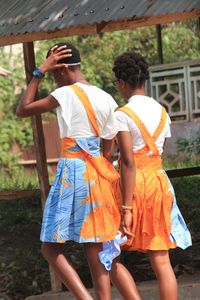 Rear view of man and woman standing against orange