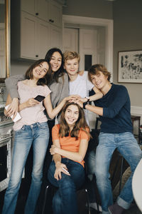 Portrait of smiling friends in living room at home