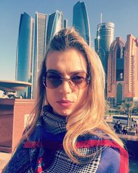 Portrait of beautiful woman wearing sunglasses in city