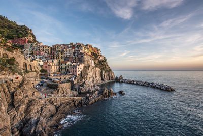 Scenic view of sea by buildings against sky