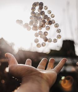 Close-up of human hand against sky